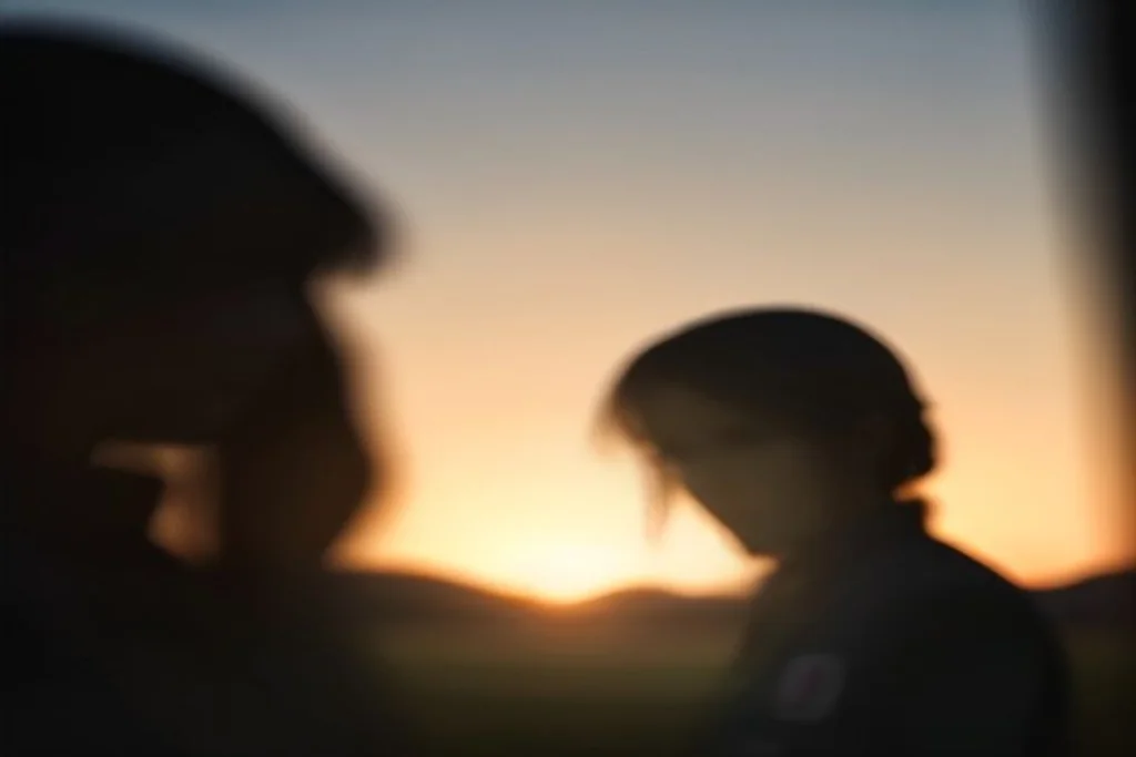 Due bandierine del calcio piantate su un campo erboso al tramonto, composizione simmetrica