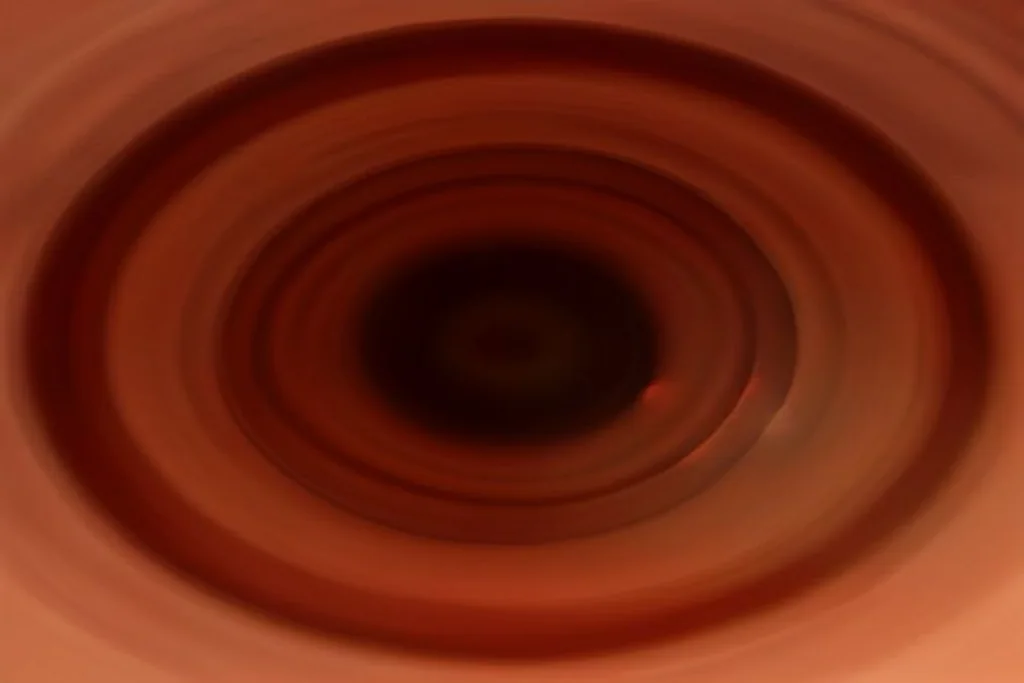 Ruota di roulette con sfera in movimento sfocato, dettaglio legno e ottone, sala vuota